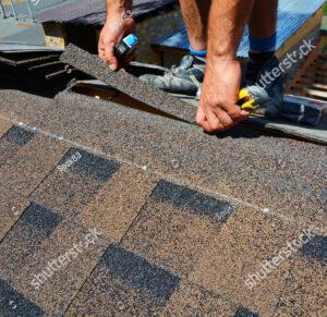 Roof repair cutting shingles